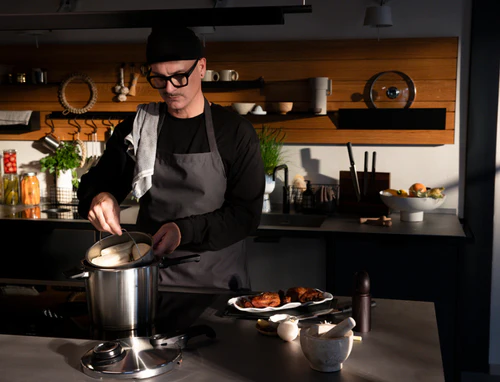 Chef cooking with Fissler pot in modern kitchen